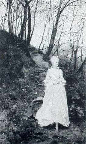 An elegant lady walking on a woodland path