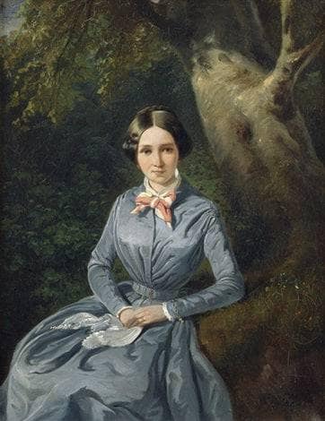 Portrait of a young woman in a blue dress, sitting in front of a tree in master bedroom