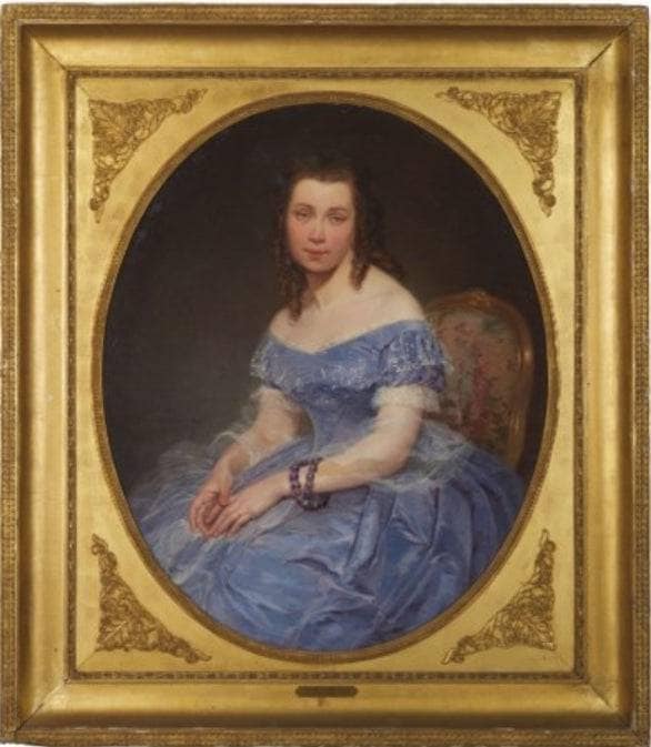 Portrait of a young woman sitting in a blue dress